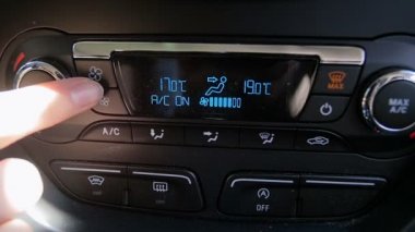 Sürücülerin gösterge panelindeki tonlamalara el basarak ve klimayı ayarlamalarının yavaş çekim yakın çekim videosu