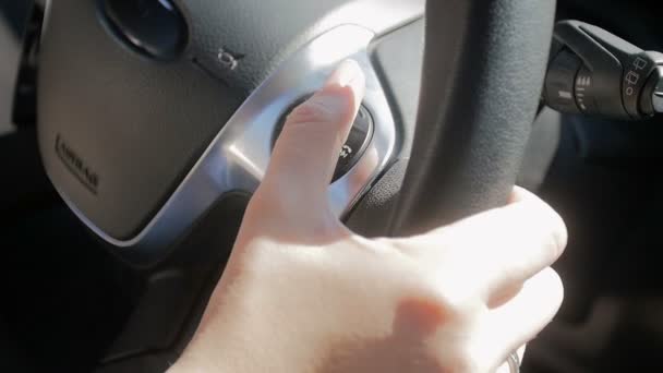 Κοντινό βίντεο αργής κίνησης του οδηγού αυτοκινήτων που προσαρμόζει τον έλεγχο Cruise και ακτίνες αυτοκινήτου χρησιμοποιώντας κουμπιά στο τιμόνι — Αρχείο Βίντεο