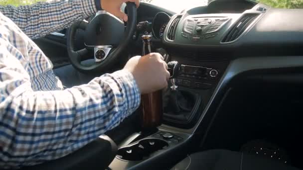 Slow motion video van onverantwoorde man rijden auto en drinken van alcohol bier. — Stockvideo