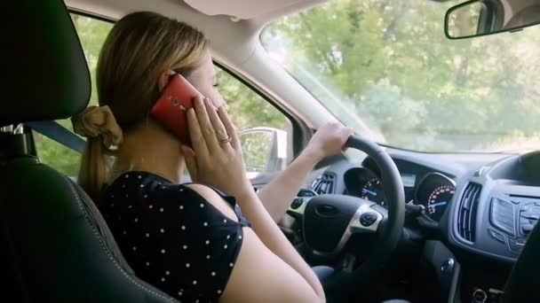 Lassú mozgás videó a felelőtlen női vezető beszél telefonon vezetés közben egy autó. Kihangosítás használata az Ön biztonsága végett — Stock videók