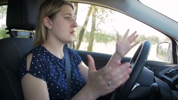 Slow motion video of frustrated young woman shouting and getting mad while driving a car — Stock Video