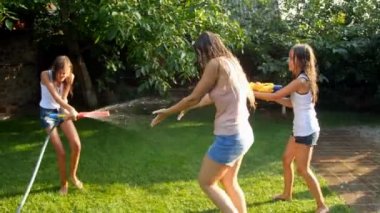 Mutlu aile arka bahçesinde birbirlerine su sıçrayan yavaş hareket video