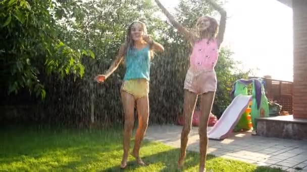Vídeo en cámara lenta de chicas adolescentes alegres bailando y saltando con manguera de jardín en el caluroso día de verano — Vídeos de Stock