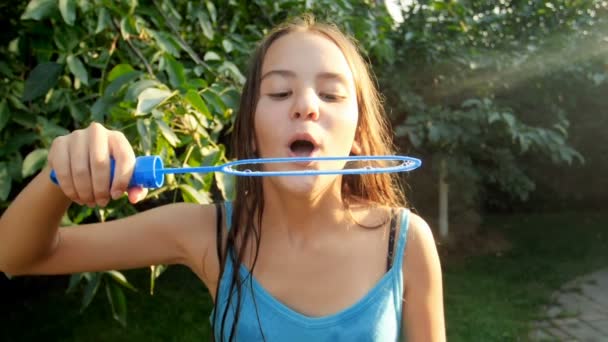 Lassított videó gyönyörű tizenéves lány fúj szappan buborék Park — Stock videók