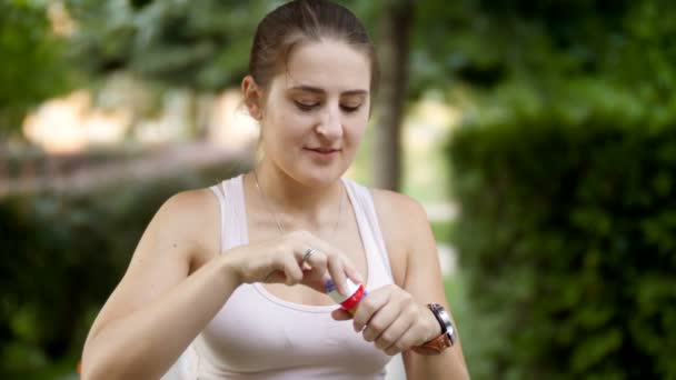 4k closeup video of beautiful smiling young woman blowing soap bubbles in park — Stock Video