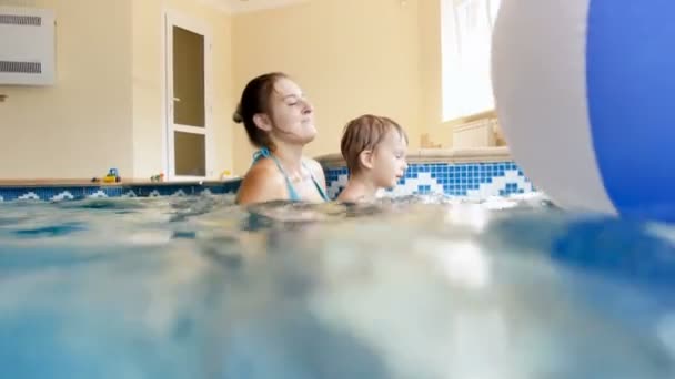 4K video av glada leende ung mamma med 3 år gamla småbarn pojke simma och spela i poolen på gym — Stockvideo