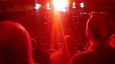 Açık hava spor arenasında rock konserinde müzik ve dans eden büyük kalabalığın 4k bulanık video