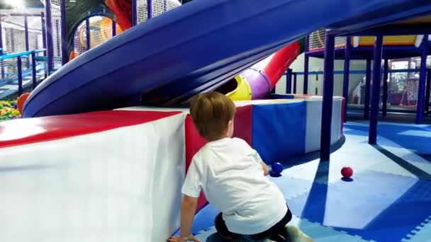 Images 4k d'un tout-petit garçon actif marchant et grimpant sur une aire de jeux dans un grand centre commercial — Video