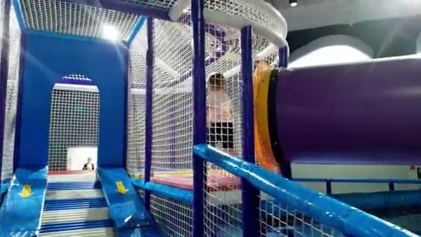 4k-beelden van 3 jaar oude peuter jongen wandelen en klimmen op grote speelplaats in pretpark — Stockvideo