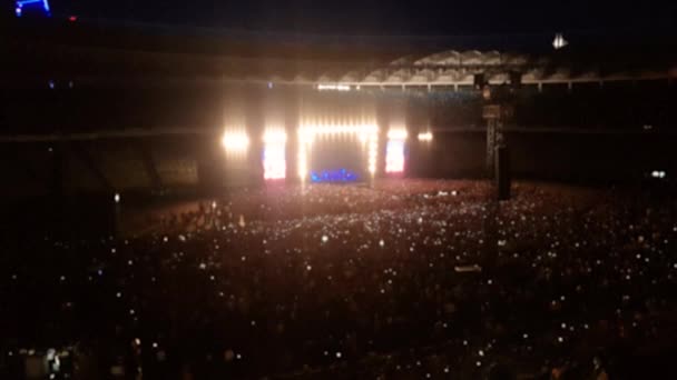 4k out of focus video van heldere kleurrijke lichten op rock concert scene. Menigte van mensen die naar muziek luisteren op sport arena — Stockvideo