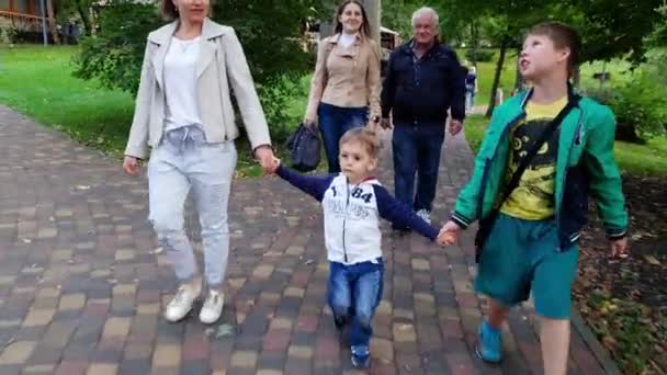 4K video av lycklig stor familj med småbarn pojke gå i vackra höst Park innehav av händer — Stockvideo