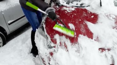 Güzel kadın sürücü sabah kar fırtınası sonra kardan arabasını temizlik 4k video