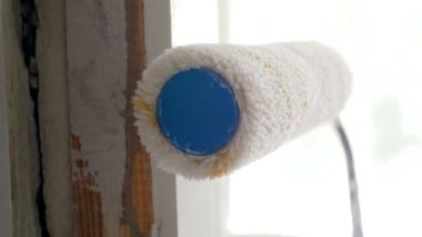 Boya rulo ile eski ahşap kapı çerçevesi boyama Closeup yavaş çekim görüntüleri. Çalışma araçları yenileme Makro video