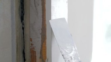 Evde yenileme yaparken spatula ile eski duvara tesviye macun Closeup yavaş hareket video