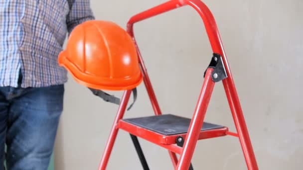 Close-up slow motion video van mannelijke construcition werknemer of bouwer opstijgen Hard Hat en schudden stof uit zijn handen na renovatie in nieuw huis — Stockvideo