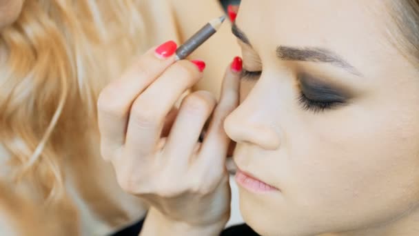 Close-up 4k-beeldmateriaal van mode modellen face terwijl professionele make-up artiest mascara en oogschaduwen op het gezicht aanbrengt voor fashion show — Stockvideo