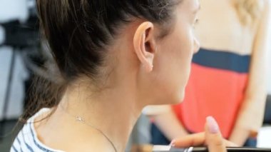 Profesyonel visagiste boyama modelleri gözleri Closeup yavaş çekim görüntüleri. Maeup sanatçı stüdyoda kızların yüzüne makyaj uygulayarak