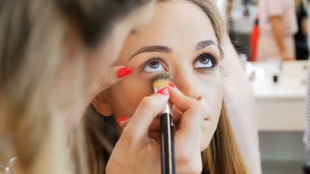 Closeup imagens em câmera lenta do artista de maquiagem profissional aplicando maquiagem em modelos rosto antes do desfile de moda — Vídeo de Stock