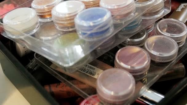 Closeup vídeo em câmera lenta de variedade de cosméticos, tons, tintas e cremes em estúdio de maquiador profissional — Vídeo de Stock