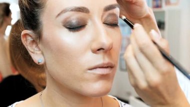 Profesyonel makyaj sanatçısı nın defile den önce mankenlerin yüzüne makyaj uyguladığı closeup slow motion görüntüleri