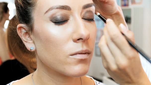 Closeup imagens em câmera lenta do artista de maquiagem profissional aplicando maquiagem em modelos rosto antes do desfile de moda — Vídeo de Stock