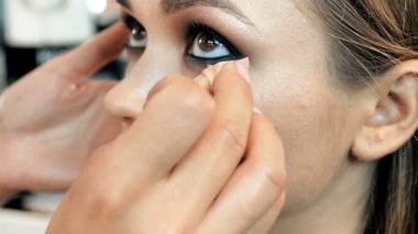 Profesyonel visagiste boyama modelleri gözleri Closeup yavaş çekim görüntüleri. Maeup sanatçı stüdyoda kızların yüzüne makyaj uygulayarak