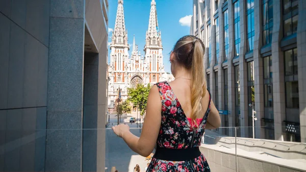Retrato de una hermosa joven en vestido corto caminando por la ciudad vieja con edificios modernos y antiguos. Turismo femenino ciudad europea de turismo — Foto de Stock