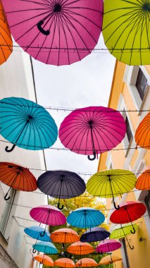 Güzel renkli şemsiye eski çekici de bina arasında asılı. Sokakta modern sanat enstalasyon