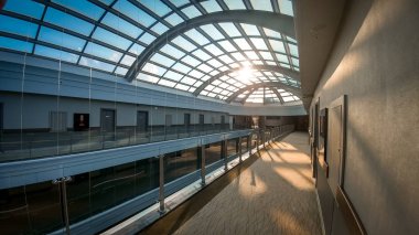 Modern ofis binası veya otelde uzun koridorlar ve güzel cam çatı Fotoğraf. Çatıdan parlayan güneş