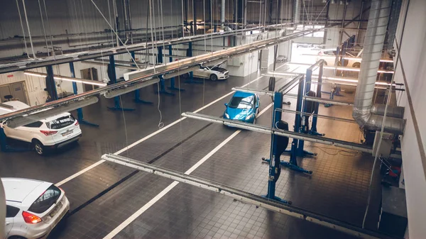 Gestemde foto van autuomobile onderhoud station met veel gereedschappen en liften voor auto reparment — Stockfoto