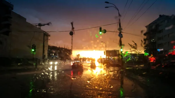 Widok przez przedniej szyby samochodu mokrej drogi po deszczu o zachodzie słońca — Zdjęcie stockowe
