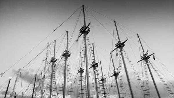 Imagem em preto e branco de muitos mastros de madeira de navios históricos no porto marítimo — Fotografia de Stock