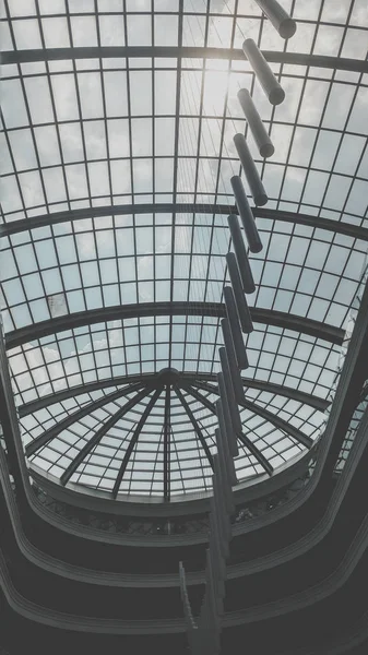 Schwarz-Weiß-Bild von Glasdachkuppel und Licht, das an der Decke eines modernen Bürogebäudes hängt — Stockfoto