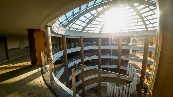 Foto de largos pasillos y hermoso techo de cristal en el moderno edificio de oficinas u hotel. Sol brillando a través del techo —  Fotos de Stock