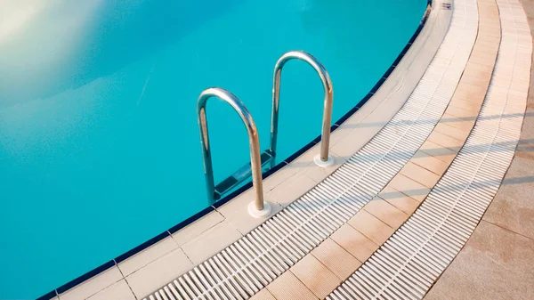 Closeup image of metal starcase on the poolside at early sunny morning — Stock Photo, Image