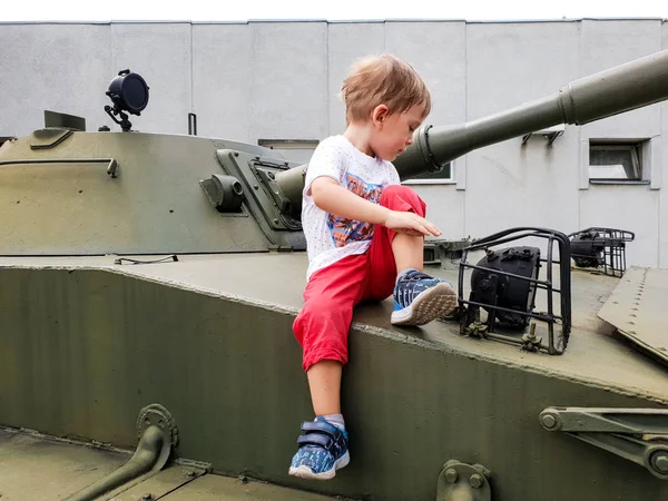 Изображение маленького мальчика, сидящего на башне танка в музее мировой войны — стоковое фото