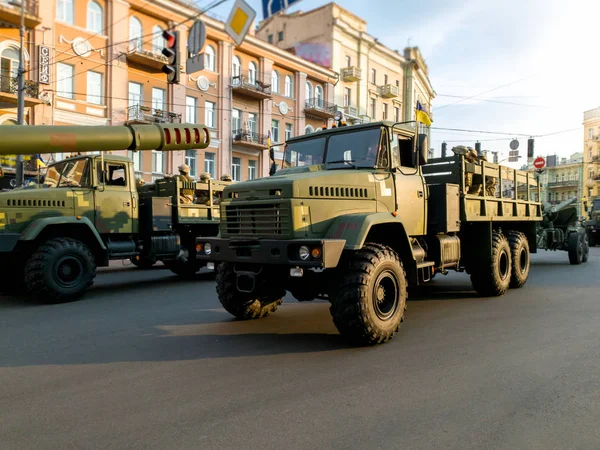 Фото больших военных грузовиков, раскрашенных в хаки и зеленую езду по улицам города — стоковое фото
