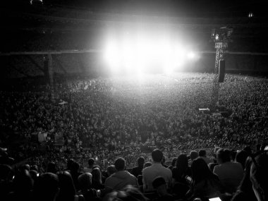 Gece rock konserinde tribünlerde insanların siyah beyaz görüntüsü.