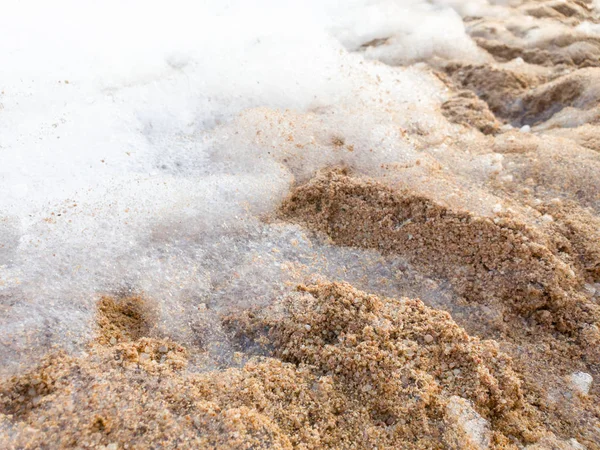 Primo piano immagine astratta di schiuma di sapone sdraiato sulla spiaggia di mare sabbioso dopo la festa discoteca spiaggia — Foto Stock