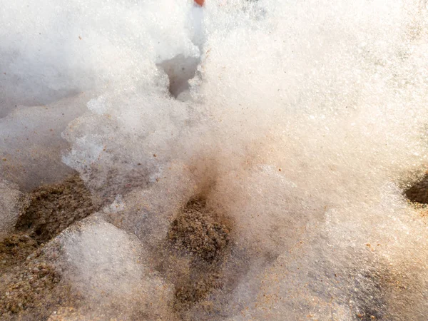 Imagen de primer plano de espuma y suds en la arena en la playa del mar. Fondo abstracto . —  Fotos de Stock