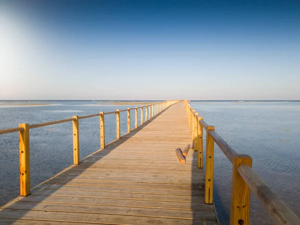 Beautiful photo of long wooden pier or bridge in the ocean — Stock Photo, Image