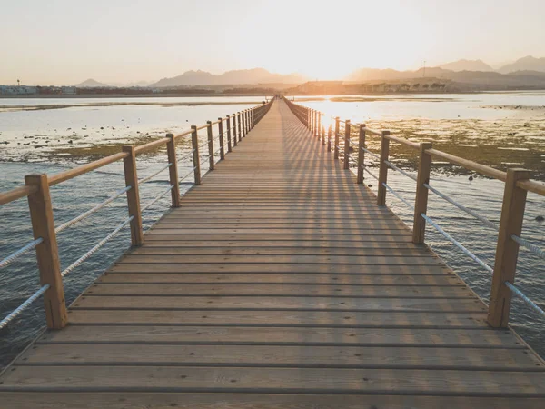 海、山、長い木製の桟橋の夕日の美しい景色 — ストック写真