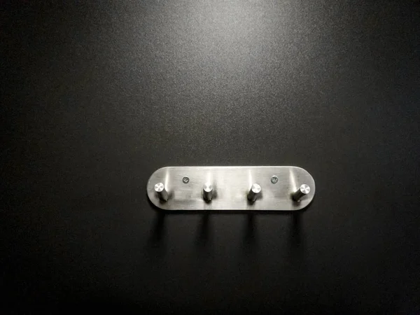 Nahaufnahme Bild von Metallhaken Kleiderbügel an der schwarzen Wand in der Garderobe — Stockfoto