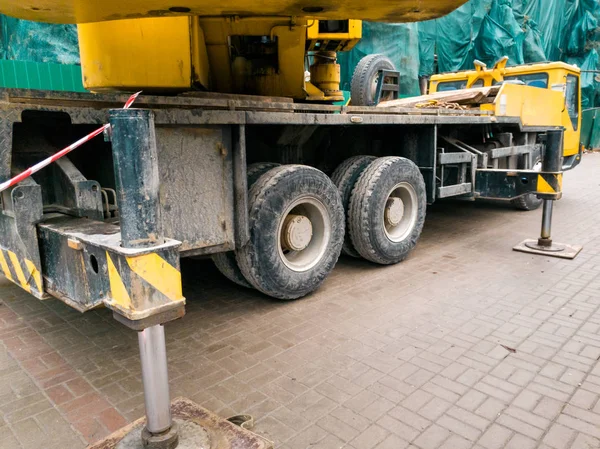 Imagen de primer plano de la grúa pesada grande de la máquina de pie en la carretera al lado del sitio de construcción — Foto de Stock