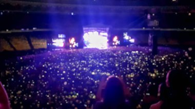 Stadyum tribünlerinde rock festivalinde müzik izleyen ve dinleyen büyük bir kalabalık. Parti, disko veya müzik festivalini göstermek için mükemmel arka plan