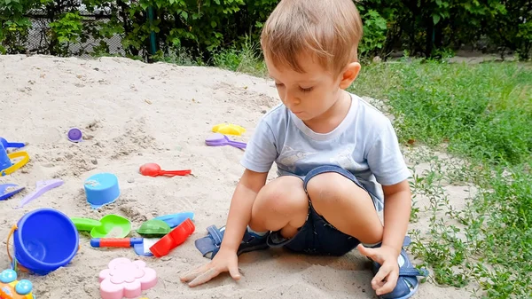 Κοντινό πλάνο φωτογραφία 3 ετών νήπιο Boy παίζει wth παιχνίδι σε άμμο στην παιδική χαρά — Φωτογραφία Αρχείου