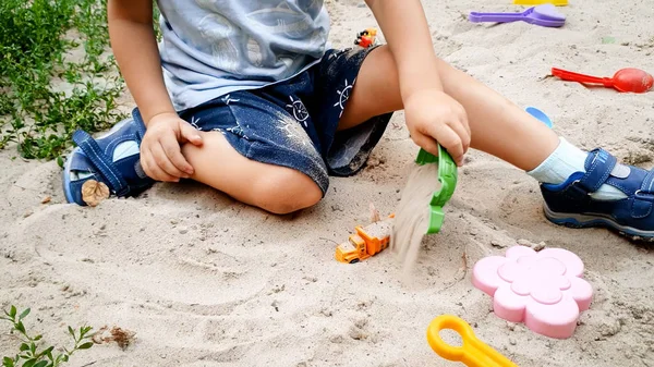 Zbliżenie zdjęcie 3 lat chłopiec maluch gra WTH zabawka w piaskownicy na placu zabaw — Zdjęcie stockowe