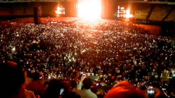 Foto borrosa abstracta de gran multitud en el concierto de rocas en el estadio por la noche. Fondo perfecto para ilustrar fiestas, discotecas o festivales de música —  Fotos de Stock
