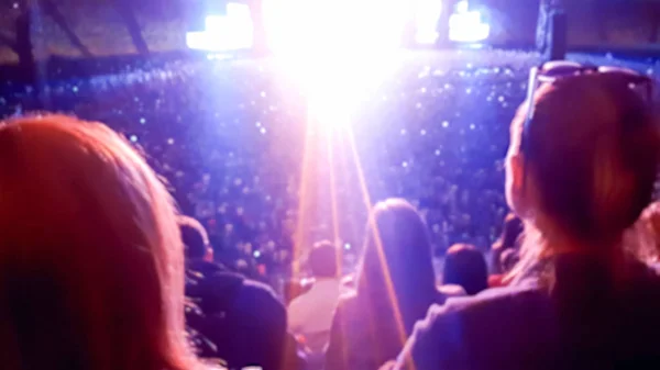 Большая толпа смотрит и слушает музыку на рок-фестивале на трибунах стадиона. Идеальный фон для иллюстрации вечеринки, дискотеки или музыкального фестиваля — стоковое фото