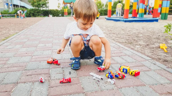 Porträtt av bedårande småbarn pojke leker med massor av färgglada leksaker på barnen Palyground — Stockfoto